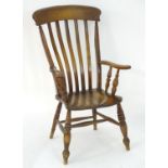 A late 19thC lathe back Windsor open arm chair with scroll arms, turned supports and raised on