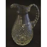 A 19thC glass jug, decorated with fluted, oval and diamond cuts, standing 5 3/4" tall Please