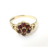 An 18ct gold ring set with garnets, diamonds and seed pearls. Ring size approx size P Please