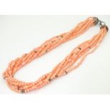 A 7-strand necklace of pink coral coloured beads with silver clasp. Approx 18" long Please Note - we