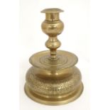A late 17th / early 18thC Dutch brass candlestick with a knopped stem, broad drip pan and bulbous