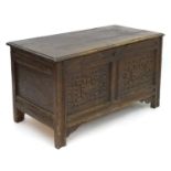 A 17thc oak coffer of peg jointed construction with a hinged moulded lid above panelled sides and