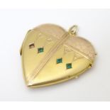 A gilt metal pedant locket of heart form. Approx. 1 1/2" long Please Note - we do not make reference