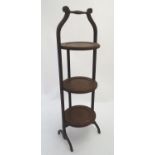 An early 20thC mahogany folding three tier cake stand. 35" high. Please Note - we do not make