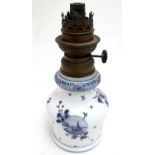 A Continental white glass oil lamp, decorated with hand painted floral vignettes and windmills, 8 /