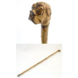 A 20thC walking cane with carved dog head handle. Approx. 35 3/4" Please Note - we do not make