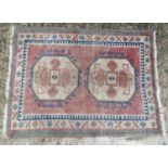 Carpet / Rug : A rug with two cream medallion motifs with geometric detail on a salmon red ground