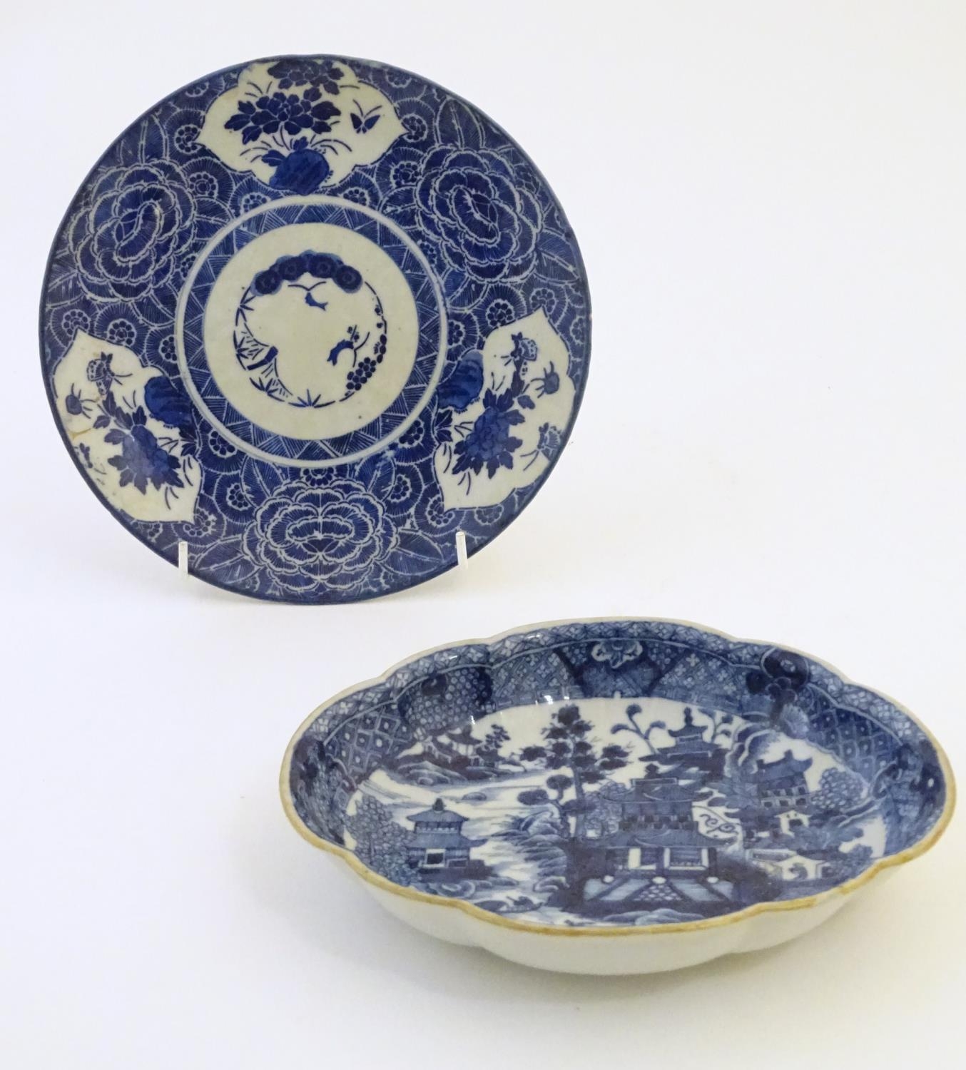 An Oriental blue and white plate with stylised peony detail, and stylised scrolling flower motifs to