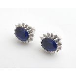 A pair of silver stud earrings set with blue and white stones Please Note - we do not make reference