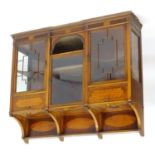 An early 20thC mahogany hanging cupboard with a moulded cornice above three glazed doors and two