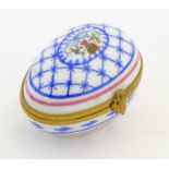 A Limoges hand painted trinket box of egg form with bell and floral detail. Marked under. Approx.