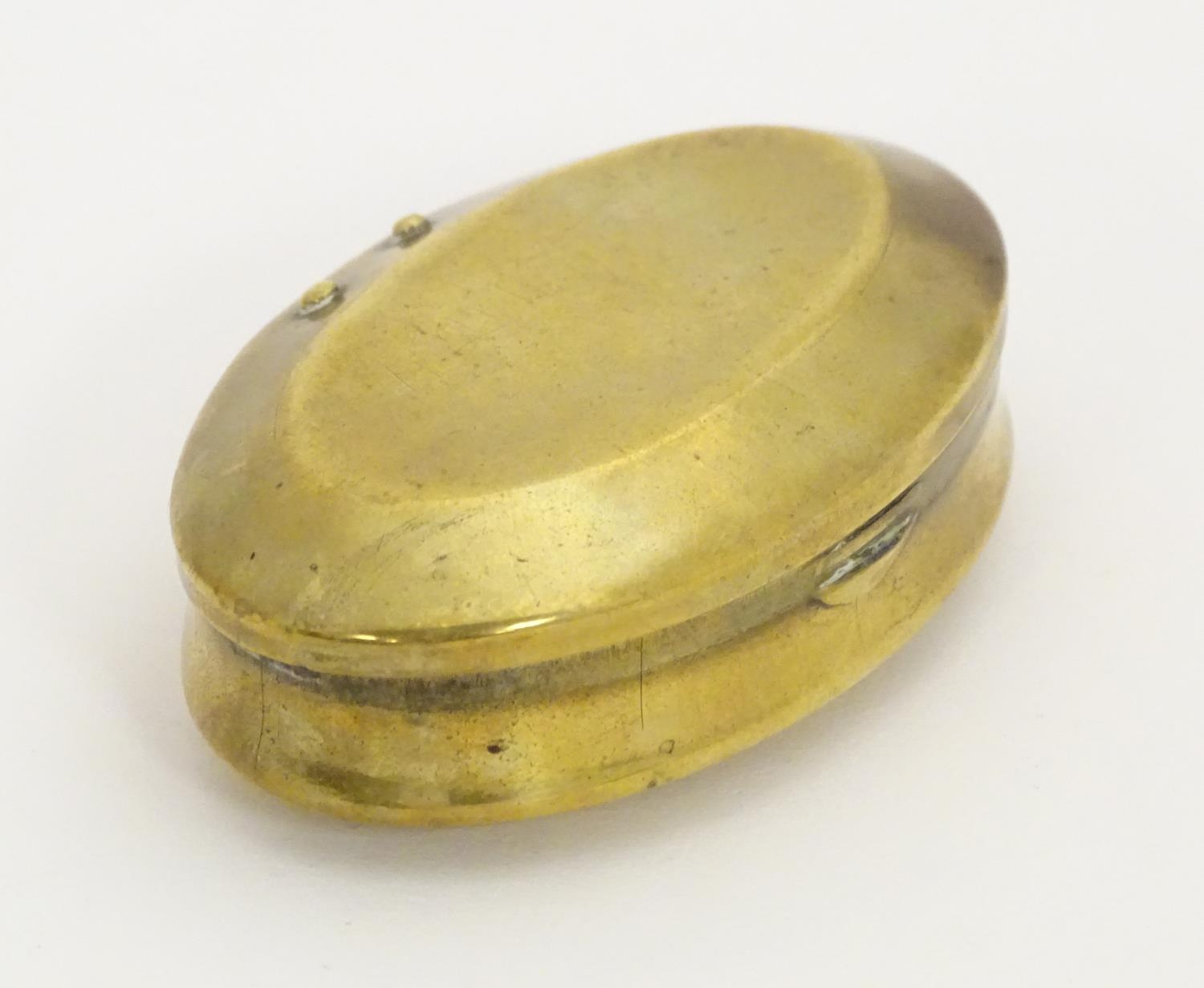 A Victorian brass snuff box of oval form, marked under Solid Brass. Approx. 1 3/4" x 2 3/4" Please