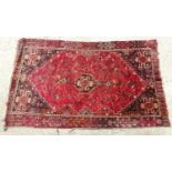 Carpet / rug : A red ground rug with central motif repeated to corners and with geometric and