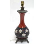 A Victorian table lamp, the ceramic body with red and black glaze with painted stylised floral