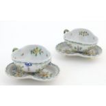 Two Continental cups and saucers of trefoil form with floral and foliate decoration and central