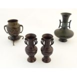 Four assorted Oriental cast vases comprising a pair of twin handled vases with relief flower and