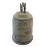 An Oriental cast temple bell the handle with twin mask detail. Approx. 19 1/4" high Please Note - we