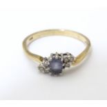 A 9ct gold ring set with central sapphire flanked by diamonds. Ring size approx P 1/2 Please