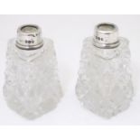 Two cut glass toilet bottles with silver collar, hallmarked London 1930, maker FW. Approx. 2 1/2"