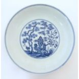 A Chinese blue and white dish with blossoming trees and stylised cactus detail. Character marks