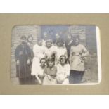 An early 20thC photograph album with sepia and monochrome photos to include group shots in the