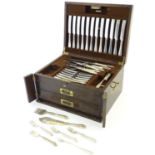An oak cased part set / canteen of silver plate cutlery to include knives, forks, spoons, servers
