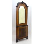 A 19thC mahogany Dutch corner cupboard with a moulded cornice and carved decoration above a mirrored