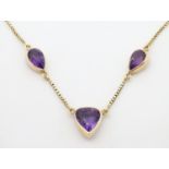 A 14ct gold necklace set with three amethysts. Marked 585. Approx 17" long Please Note - we do not