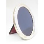 A photograph frame of oval form with silver surround hallmarked Sheffield 1979 maker Carrs of
