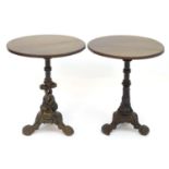 A pair of pub tables with circular mahogany tops and cast irons bases with stylised Georgian