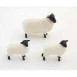 Three Beswick sheep comprising a black faced sheep model no. 1765 and two lambs, no. 1828. Marked