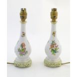 A pair of Herend pottery table lamps decorated with flowers, foliage and butterflies. Marked