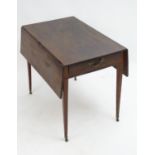 An early 19thC mahogany Pembroke table with a rectangular top flanked by two drop flaps and having a