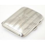 A silver cigarette case with engine turned banded decoration, hallmarked Birmingham 1923, maker