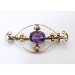 A 9ct gold brooch set with central oval amethyst. Approx. 1 1/2" wide Please Note - we do not make