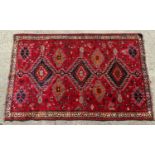 Carpet / Rug : A red ground rug with central motifs within geometric border. Approx 98" x 63" Please