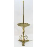 A 19thC Arts and Crafts brass standard lamp, converted to electricity, the height adjustable shaft