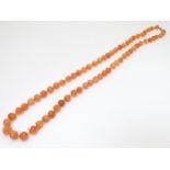 A vintage bead necklace of orange agate hardstone beads. Approx. 32" long Please Note - we do not