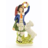 A Staffordshire pottery figure of a Highland man wearing a kilt with a sporran and a plume hat,