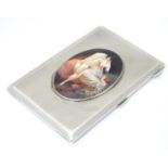 A silver cigarette case with engraving turned decoration and later applied ceramic cabochon