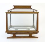 An Arts and Crafts oak table top terrarium with a sarcophagus style top having a pierced brass
