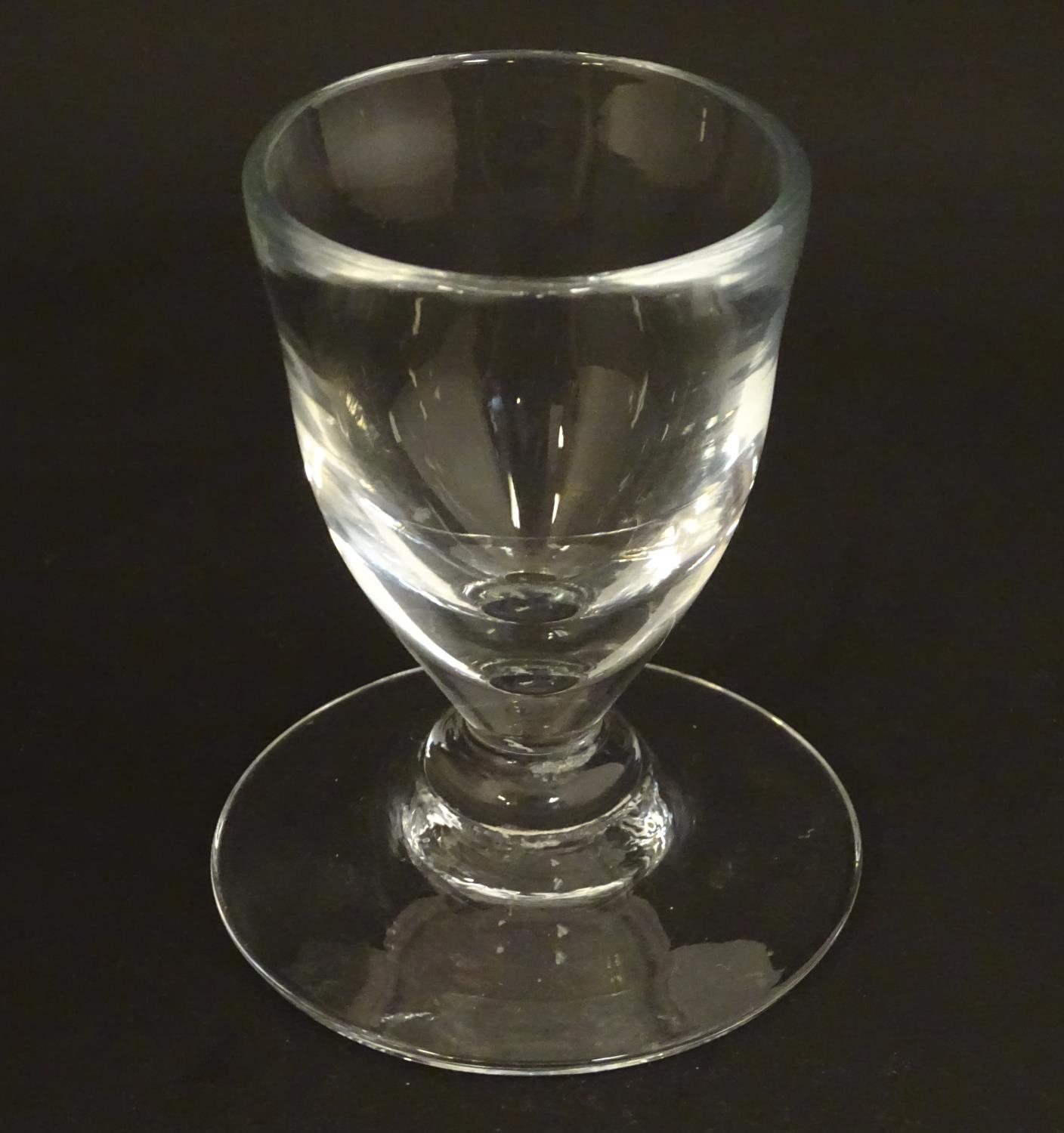 A drinking glass with wide foot. 4 1/2" high Please Note - we do not make reference to the condition