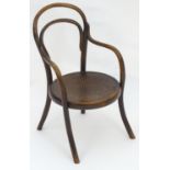 An early 20thC beech bentwood childs chair with an anthemion decorated seat and four splayed legs.