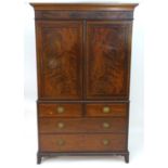 A 19thC mahogany linen press with a moulded cornice above two flame mahogany panelled doors and
