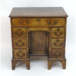 A George III mahogany secretaire kneehole desk with Chippendale style handles, having a