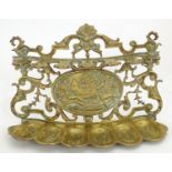 A 19thC brass pipe rack / stand with scrolling foliate detail and central relief decoration