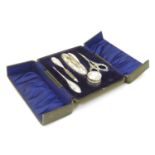 A cased manicure set comprising silver handled scissors, buffer, file etc and a silver topped pot.