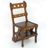 A 19thC oak metamorphic library chair / steps, having cruciform decoration and quatrefoil piercing