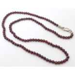 A garnet bead necklace with silver clasp. Approx. 18" long Please Note - we do not make reference to