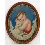 A 20thC oval needlework / embroidery depicting John the Baptist and a sheep amongst clouds, with a